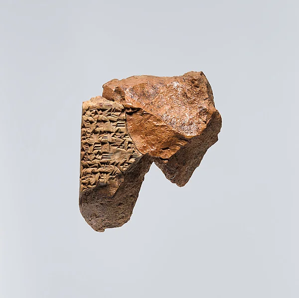 A broken clay tablet, one corner still covered in rows of cuneiform. A
                  fragment of the Babylonian epic Atra-hasis, in which humankind is made
                  out of clay.