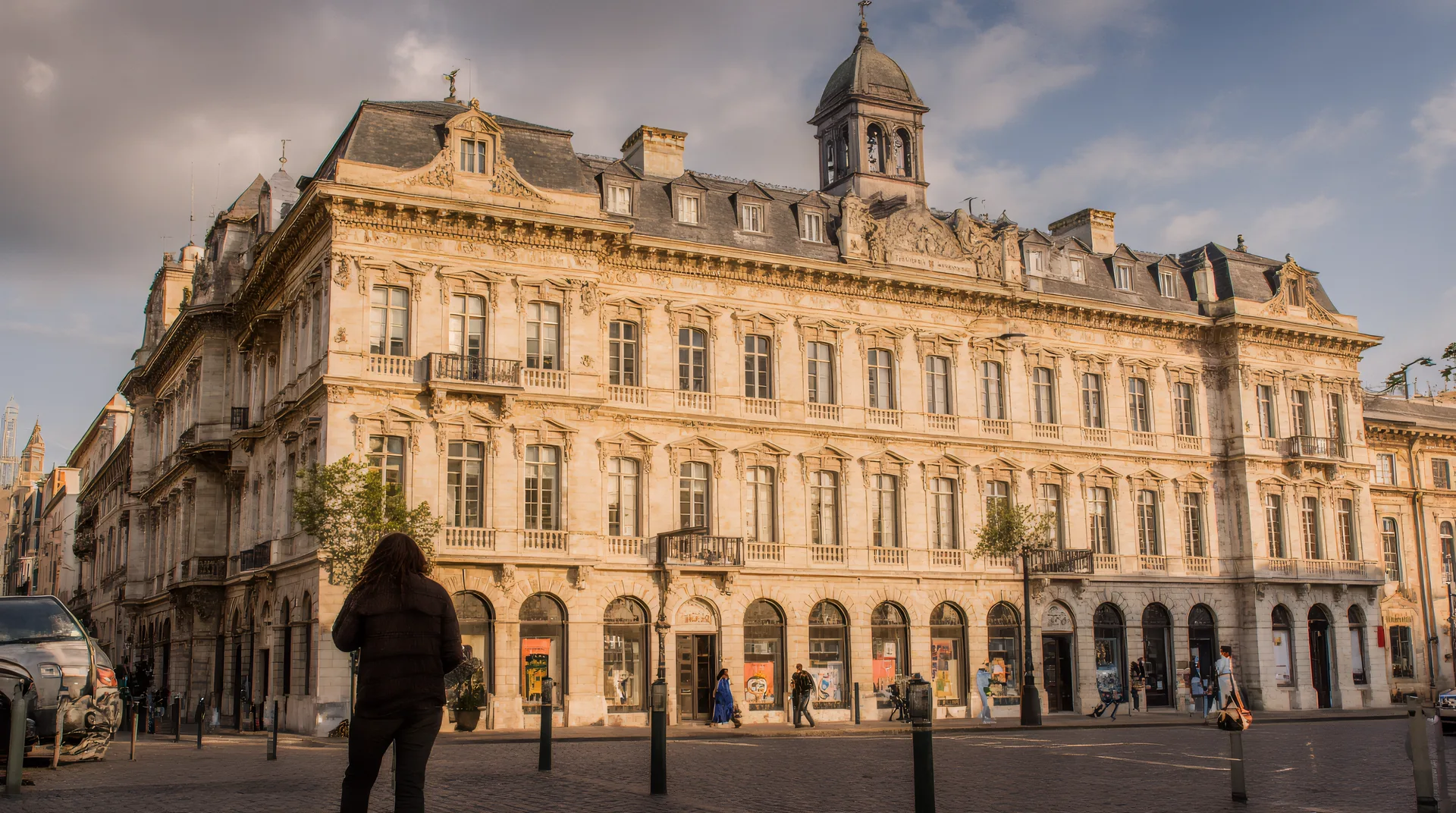 A grand historic building viewed from a European city square.