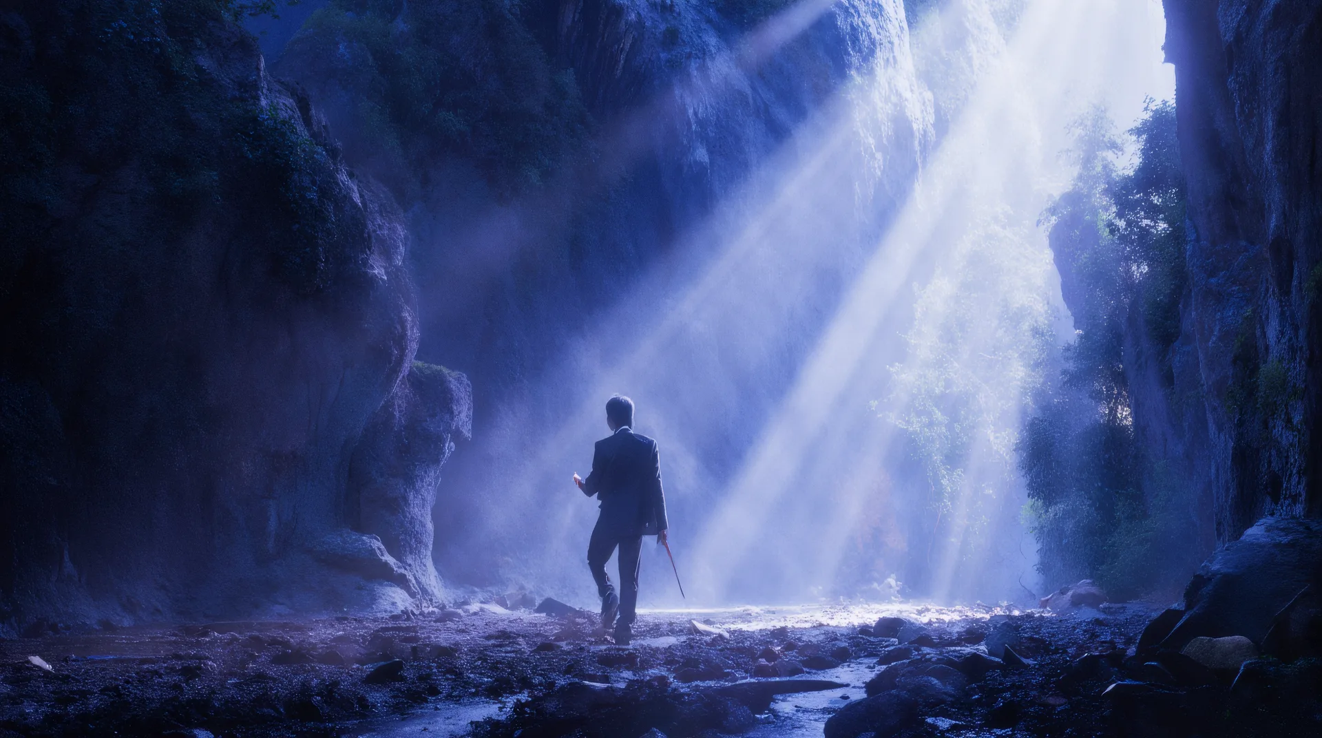 A solitary figure standing beneath shafts of blue light in a vast cavern.