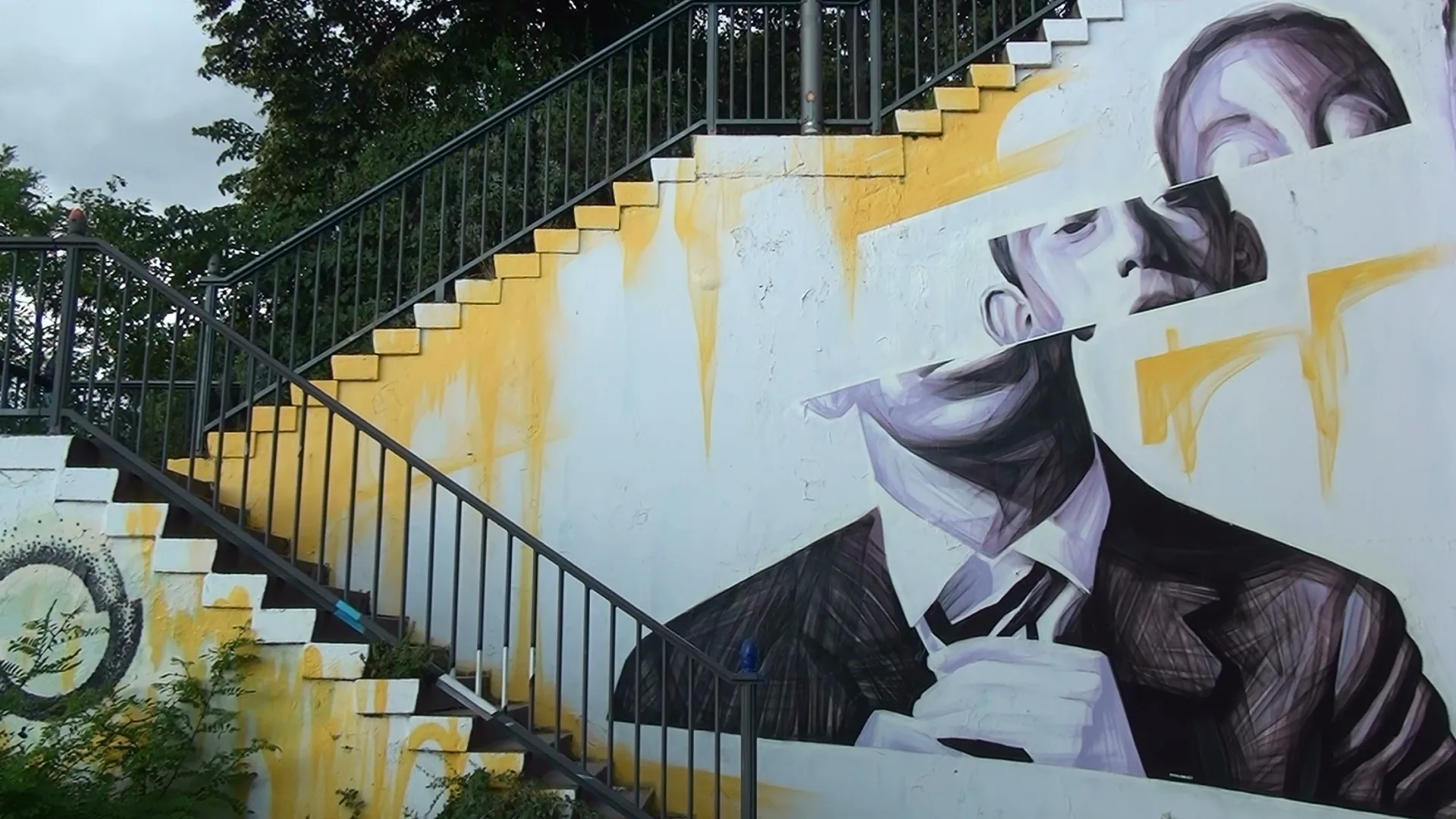 A large painted portrait mural integrated into an outdoor staircase.